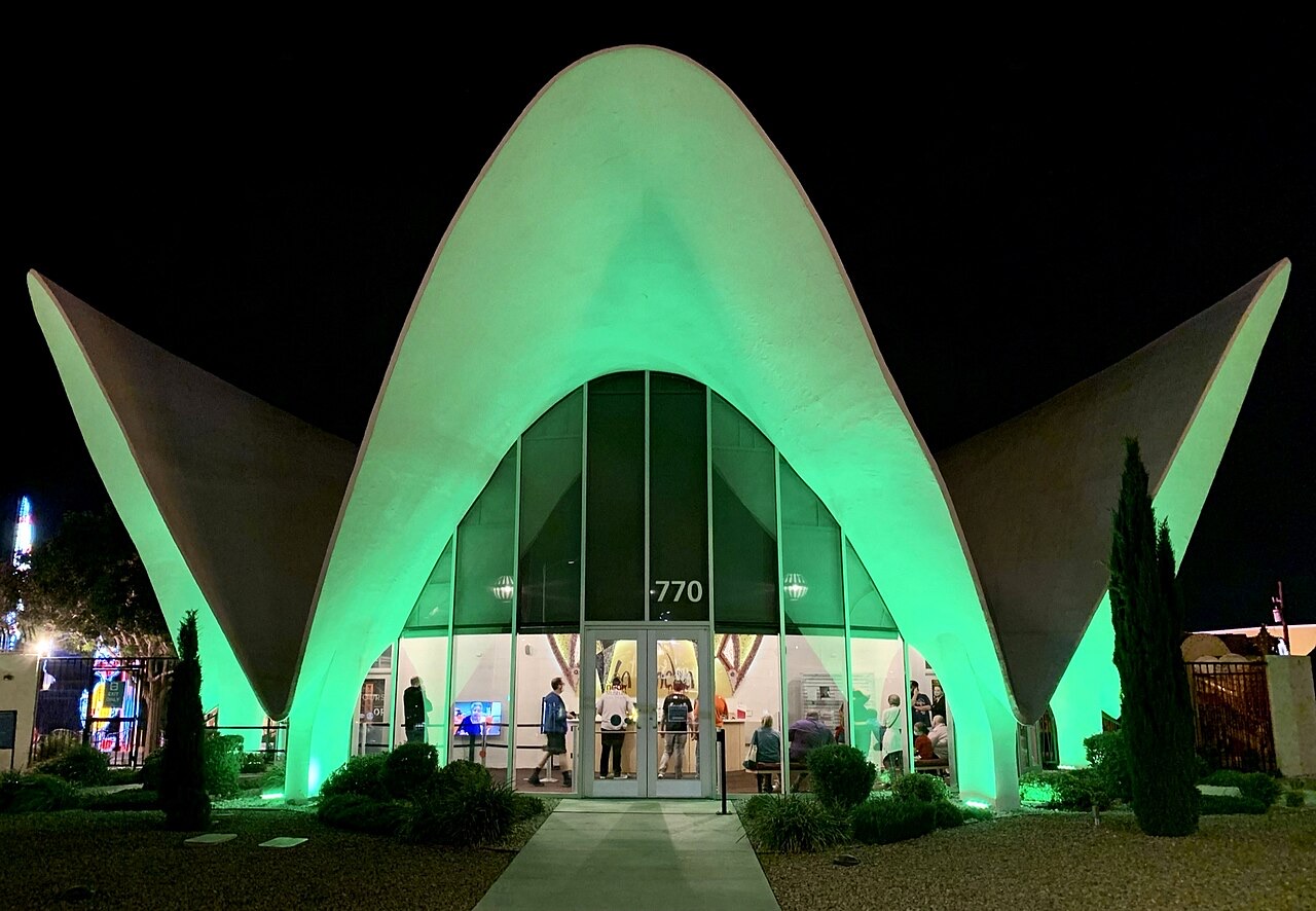 The Neon Museum's visitor center, the restored La Concha Motel lobby, lit green at night