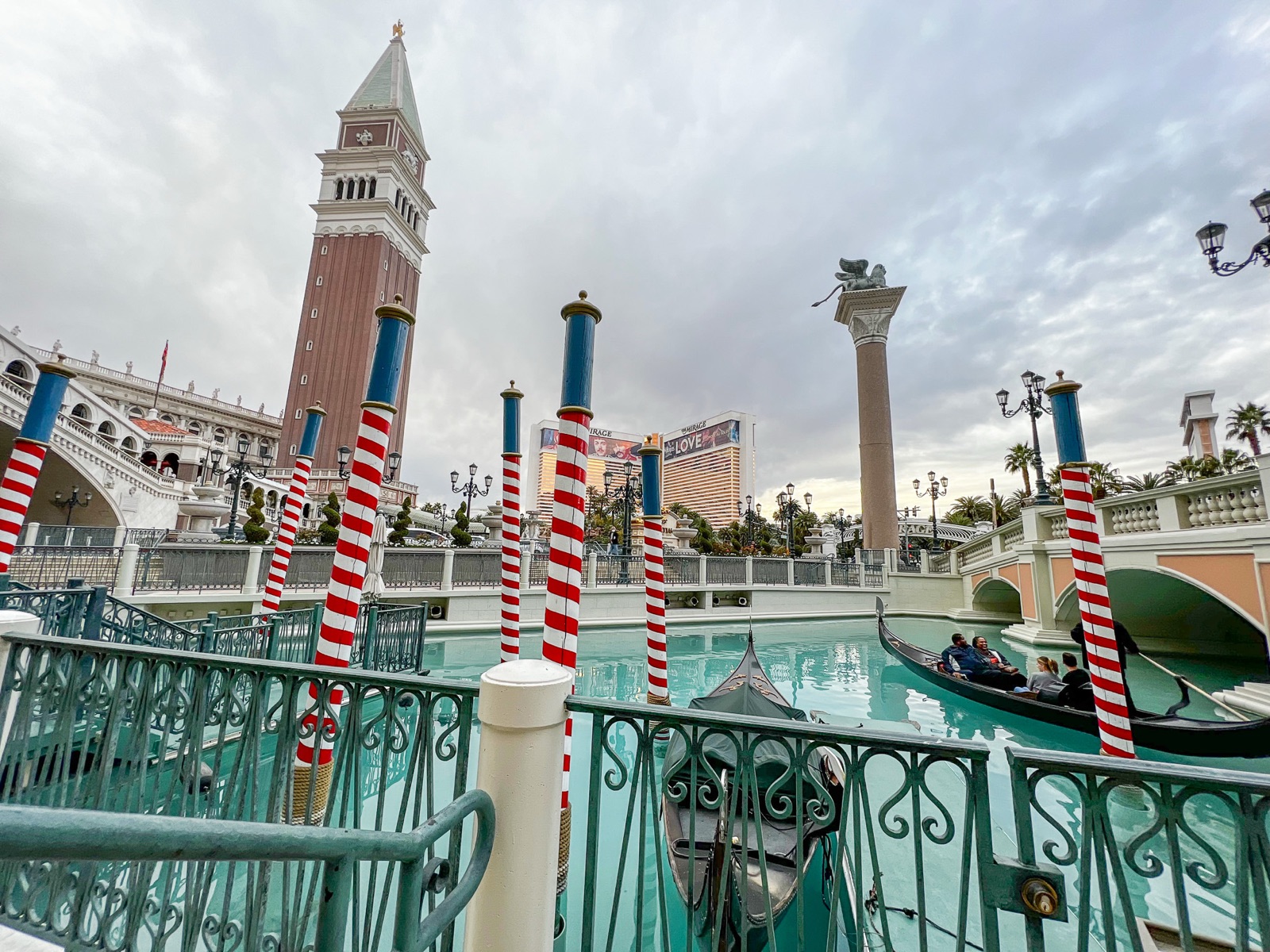 The Venetian's campanile and gondola dock with striped mooring poles, where gondola ceremonies begin
